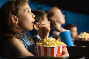 Kids eating popcorn at the movies on holidays