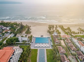 Oceanfront view of Pullman Danang Beach Resort in Vietnam with infinity pool and white sand beach