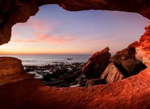 The cave frames a dusky horizon as night begins to settle in