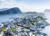 Aerial view of Norway’s fjords with deep blue waters winding between towering green mountains