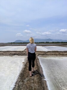 travel agent walking away over salt flats in cambodia