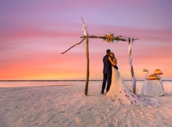 Romantic Destination Wedding on beach at sunset. Where Lovers Wander