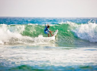 Boy surfing on green wave in Anaheim